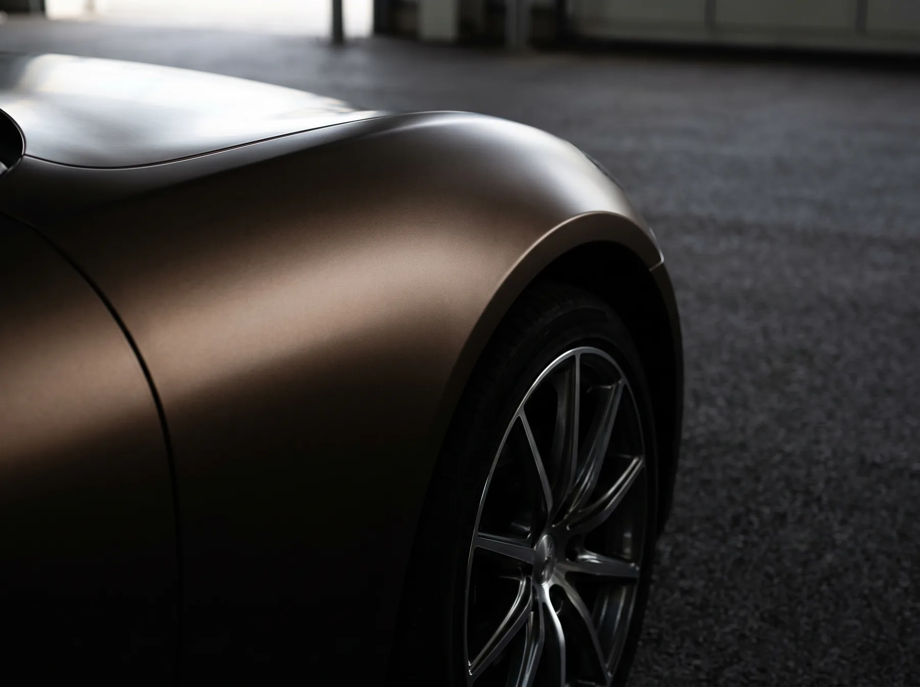 Satin bronze wrapped fender and wheel arch in raking light